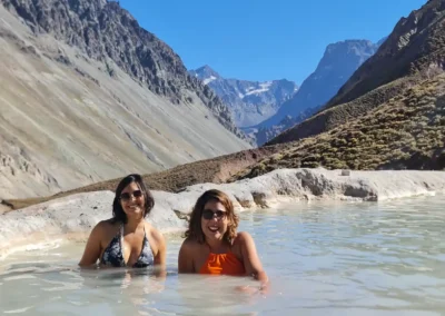 Amigas relajándose en las Termas Valle de Colina con la cordillera de los Andes de fondo