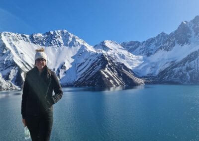 Turista feliz disfrutando la vista del Embalse El Yeso y las montañas nevadas.