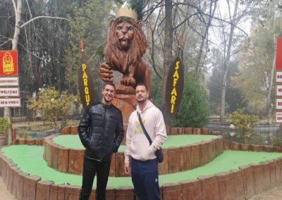 Gente posando en la estatua de león. Tour Safari Rancagua, ideal para fotos.