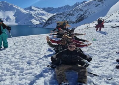 Grupo de amigos felices posando en fila y riendo en el tour al Embalse El Yeso.