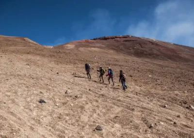 Montañistas subiendo una pendiente de arena volcánica en el tour volcan lascar