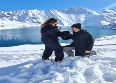 Propuesta de matrimonio sorpresa en el Embalse El Yeso con el paisaje nevado de fondo.