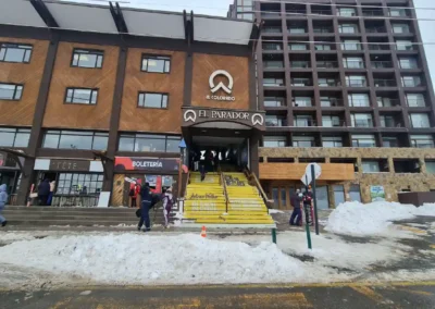 Entrada al centro de ski El Colorado en el edificio El Parador con nieve y visitantes