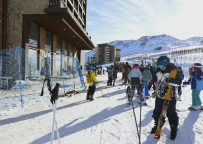 Esquiadores y snowboarders equipados en la base del centro de ski El Colorado