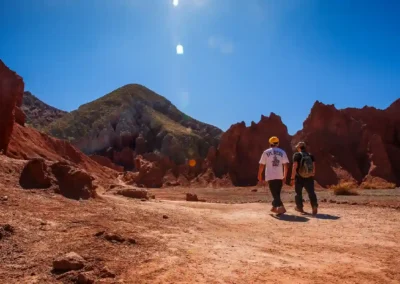 viajeros caminando por el sendero del tour valle arcoiris entre cerros de colores