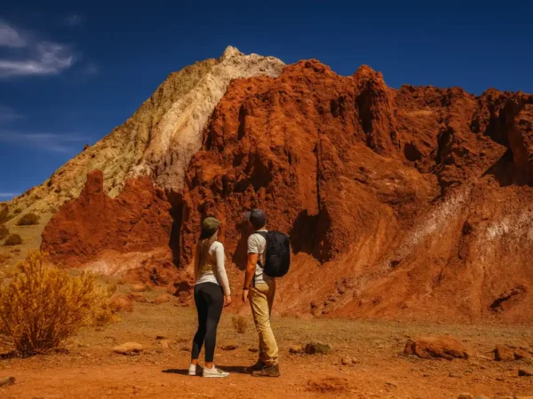 tour valle arcoiris san pedro de atacama con cerros multicolores y turistas caminando