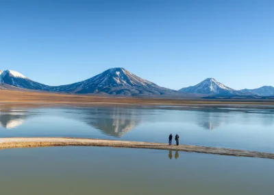 Pequeño grupo frente a una laguna altiplánica con volcanes nevados en el norte de Chile
